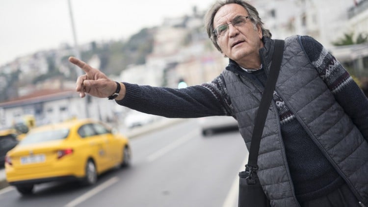 Man hailing yellow taxi on city street