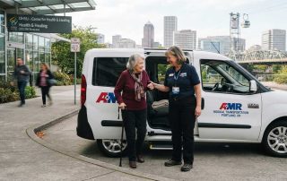 Medical transport worker assists elderly woman from van - Methadone Clinic Transportation in Portland, Oregon | Broadway Cab