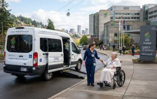 Nurse assists wheelchair patient beside OHSU medical transport van. - OHSU Medical Transportation in Portland, Oregon